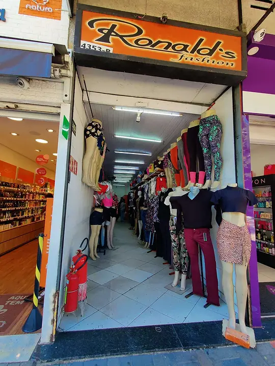 Entrada da Ronald's Fashion, com o letreiro, araras de roupas e manequins