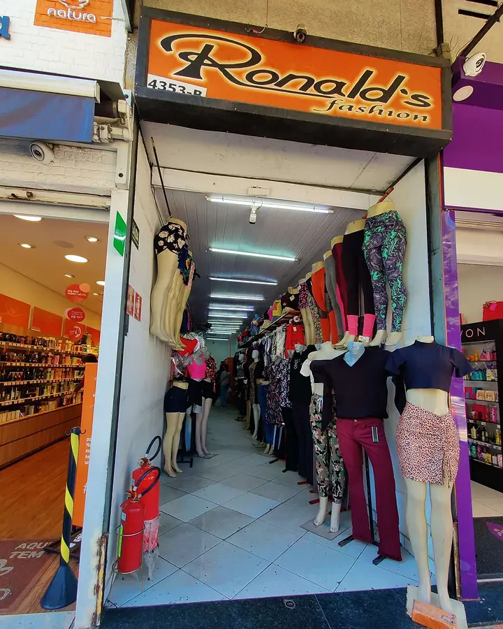 Entrada da Ronald's Fashion, com o letreiro, araras de roupas e manequins